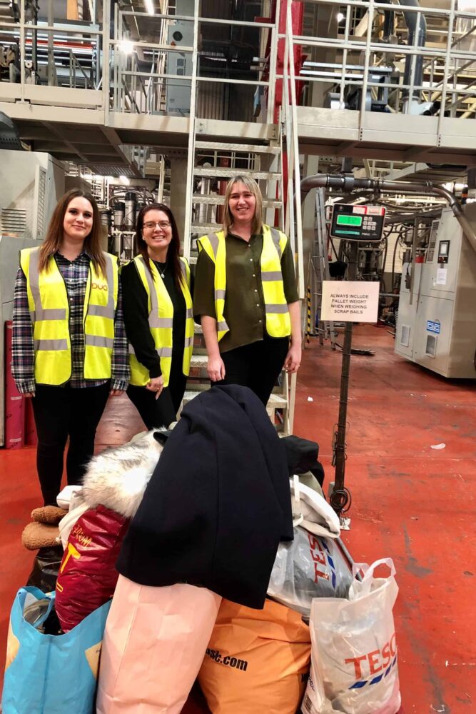 Georgia, Evi and Vicky with clothes donations on the scales